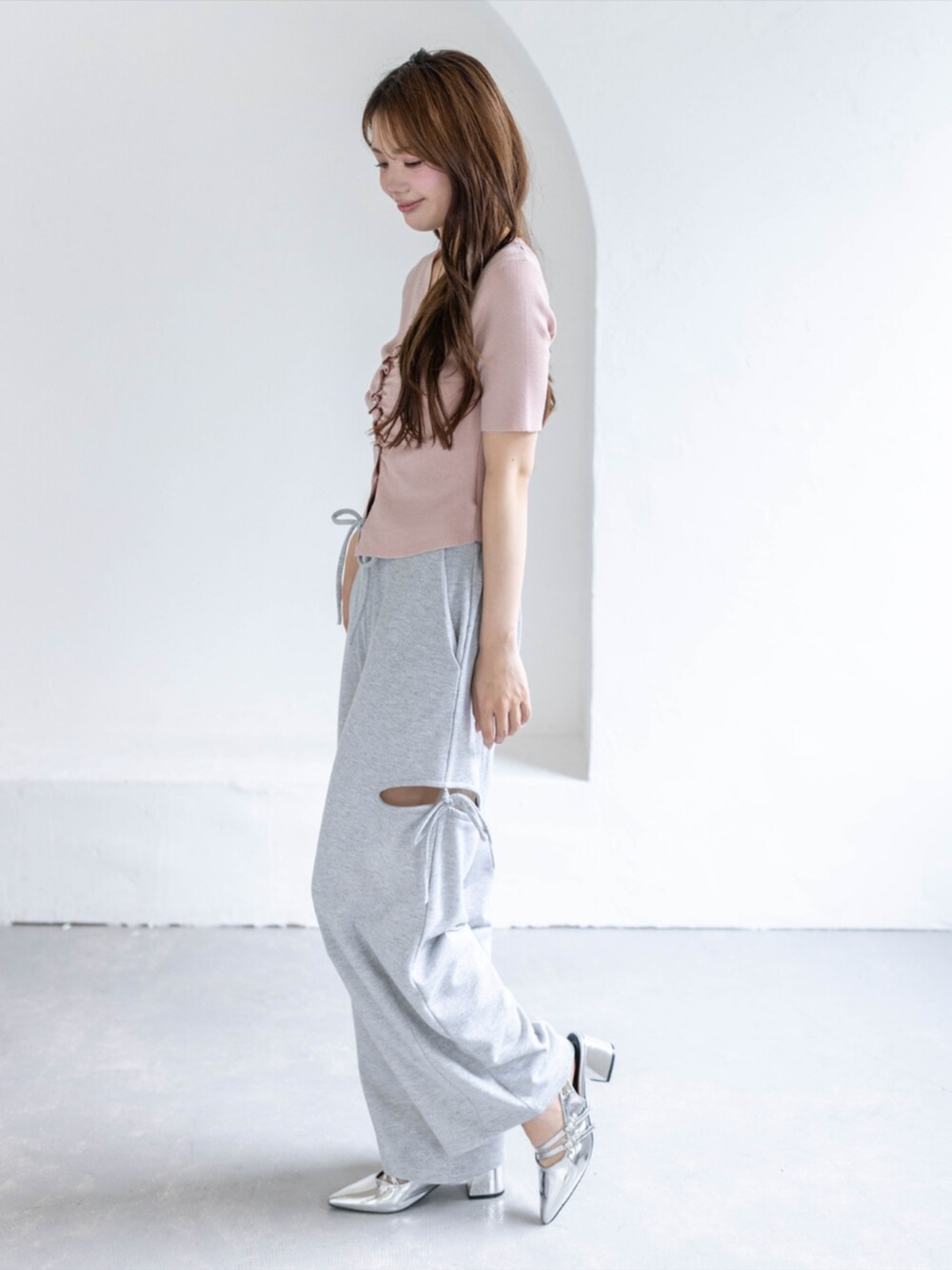 シルバー系のパンプス、グレー系のスウェットパンツ、ピンク系のカーディガン/ボレロを着用したレディースの春コーディネートの2枚目の写真