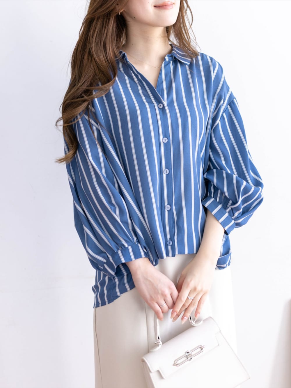 ホワイト系のスカート、ブルー系のシャツ/ブラウス、ホワイト系のパンプスを着用したレディースの夏コーディネートの6枚目の写真