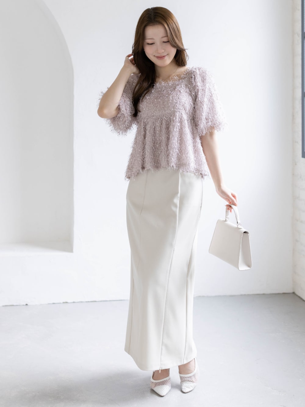 ホワイト系のスカート、ホワイト系のハンドバッグ、ホワイト系のパンプスを着用したレディースの春コーディネートの3枚目の写真