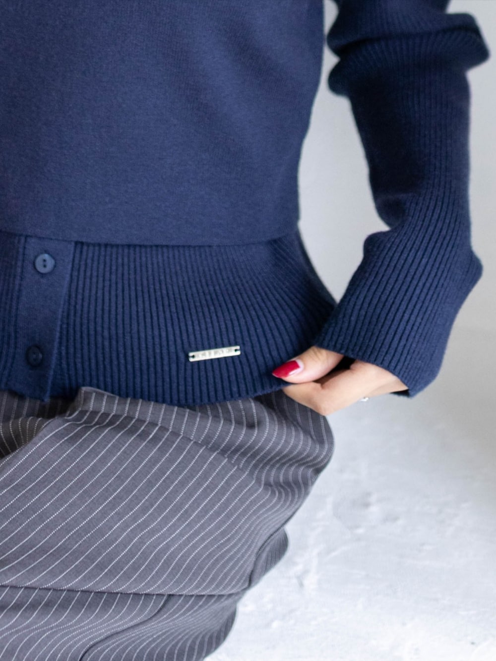 シルバー系のパンプス、グレー系のスラックス、ブルー系のニット/セーターを着用したレディースの秋コーディネートの4枚目の写真