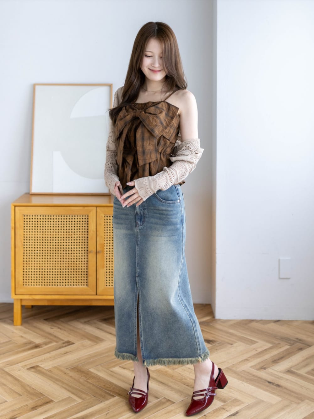 レッド系のパンプス、ブラウン系のニット/セーター、ブルー系のデニムスカートを着用したレディースの夏コーディネートの3枚目の写真
