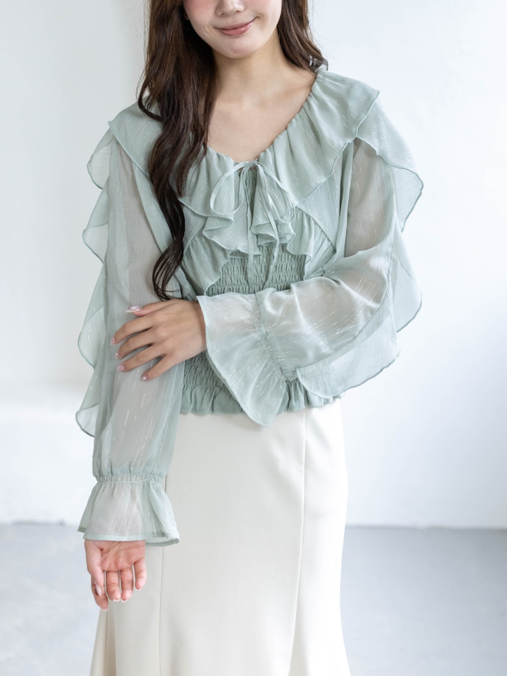 ホワイト系のスカート、ホワイト系のパンプス、グリーン系のシャツ/ブラウスを着用したレディースの春コーディネートの4枚目の写真