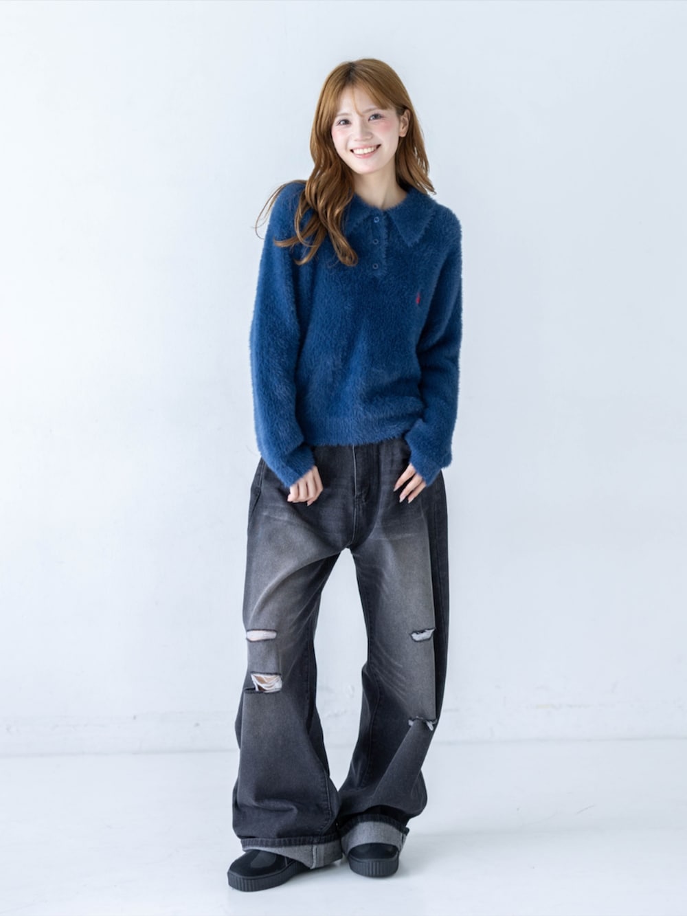 ブラック系のデニムパンツ、イエロー系のスニーカー、ブルー系のニット/セーターを着用したレディースの秋コーディネートの3枚目の写真