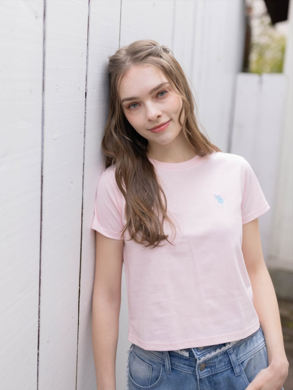 ブルー系のデニムパンツ、シルバー系のサンダル、ピンク系のTシャツ/カットソーを着用したレディースの夏コーディネートの4枚目の写真