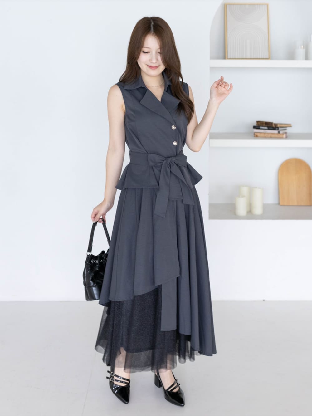 ブラック系のパンプス、グレー系のシャツ/ブラウス、グレー系のスカートを着用したレディースの夏コーディネートの3枚目の写真