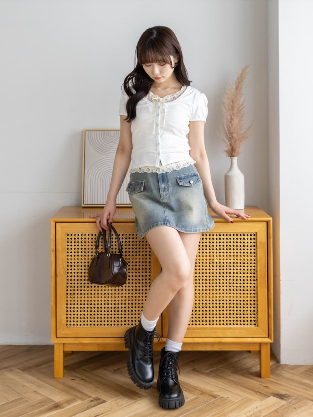 ブラック系のブーツ、ブルー系のスカート、ホワイト系のTシャツ/カットソーを着用したレディースの春コーディネートの3枚目の写真
