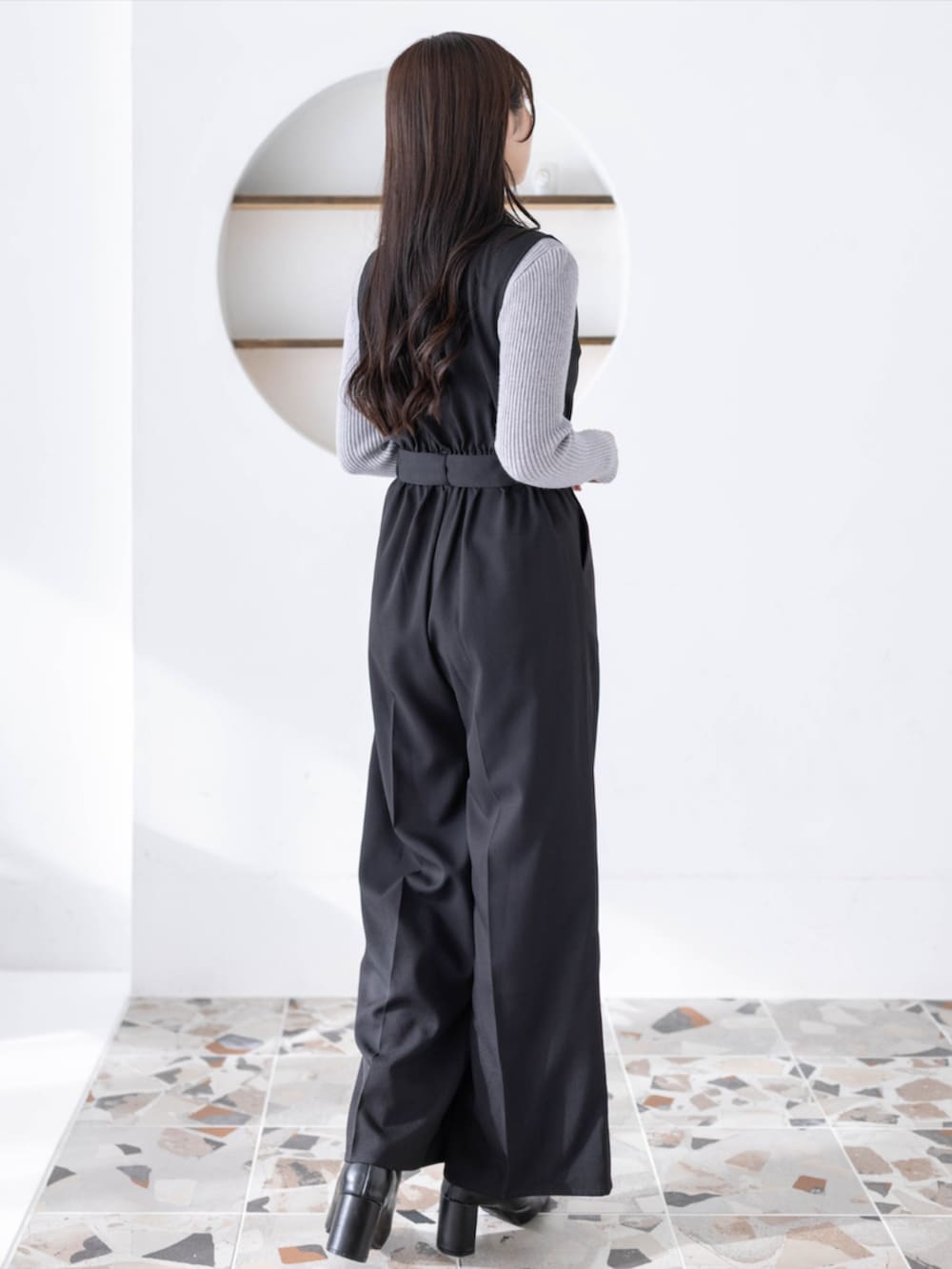 グレー系のニット/セーター、ブラック系のつなぎ/オールインワンを着用したレディースの夏コーディネートの2枚目の写真