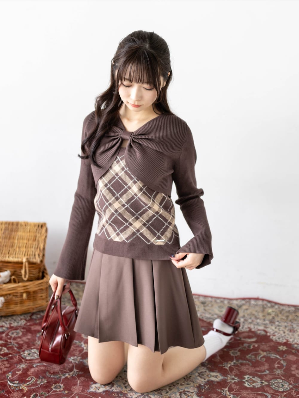 レッド系のパンプス、ブラウン系のスカート、ブラウン系のニット/セーターを着用したレディースの秋コーディネートの5枚目の写真