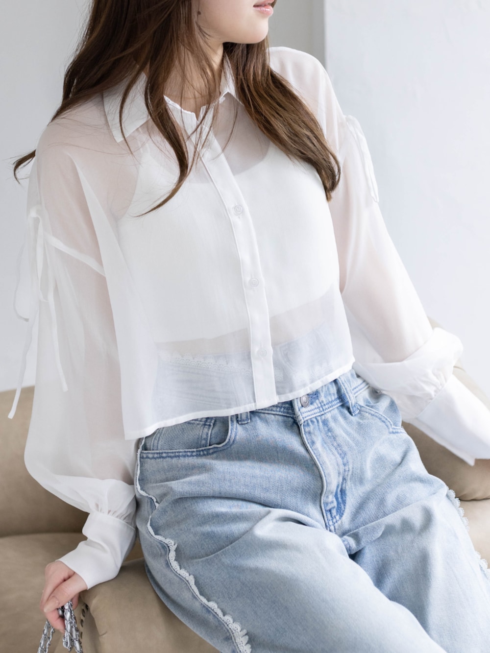 ブルー系のデニムパンツ、ホワイト系のパンプス、ホワイト系のシャツ/ブラウスを着用したレディースの春コーディネートの6枚目の写真