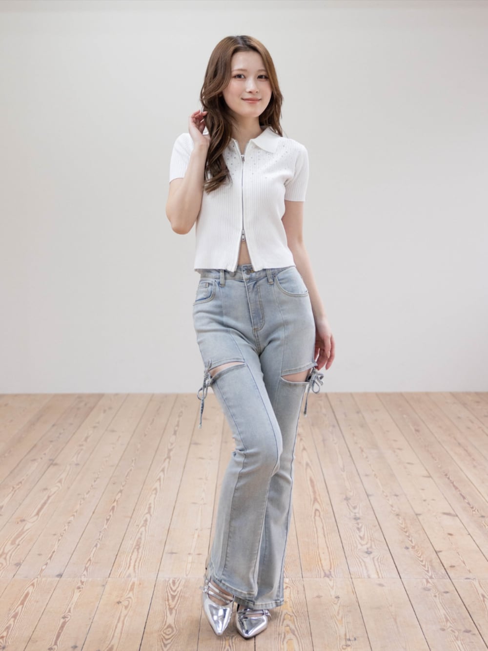 シルバー系のパンプス、ブルー系のデニムパンツ、ホワイト系のニット/セーターを着用したレディースの春コーディネートの2枚目の写真