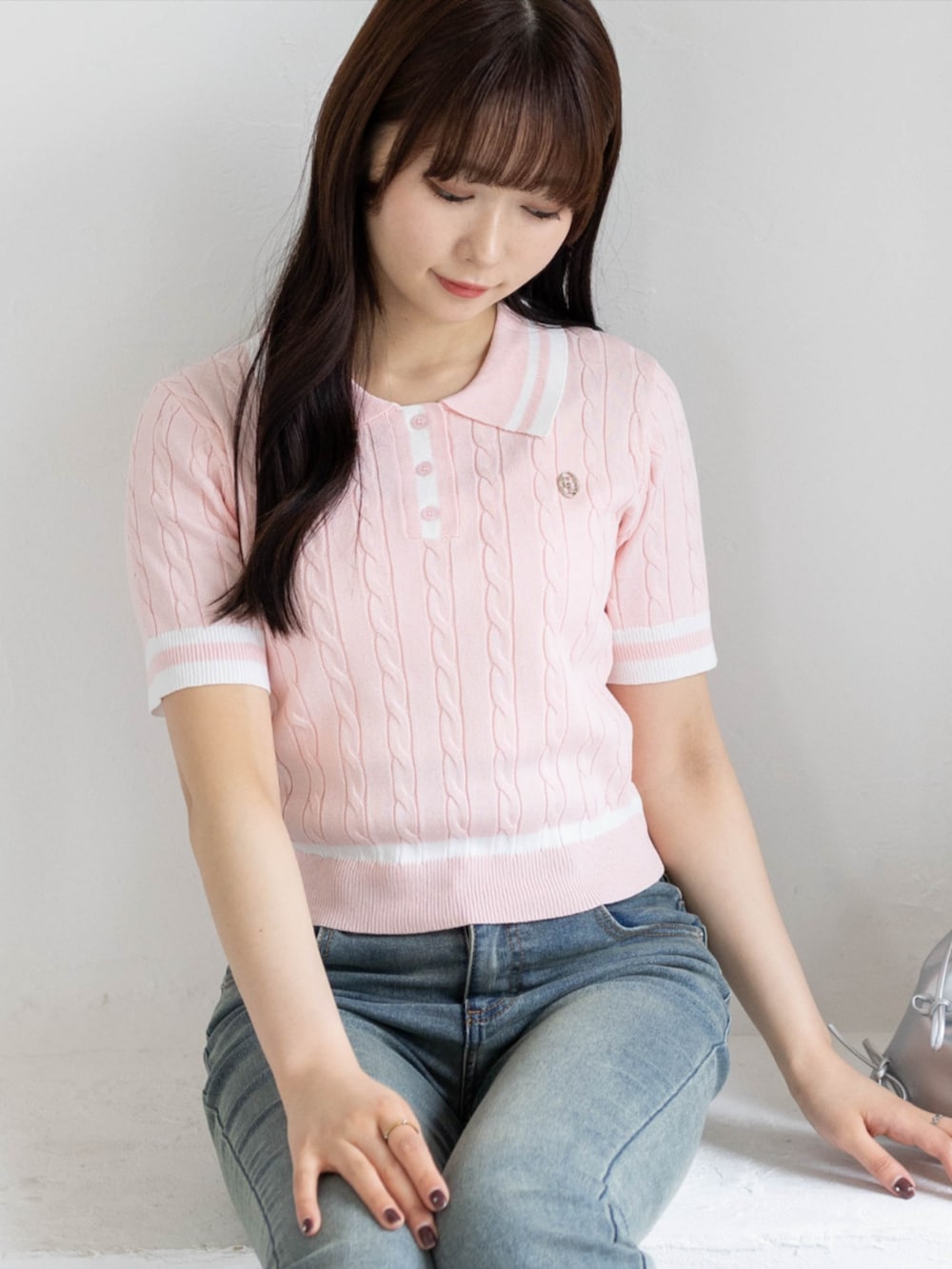 ブルー系のデニムパンツ、シルバー系のパンプス、ピンク系のニット/セーターを着用したレディースの夏コーディネートの5枚目の写真