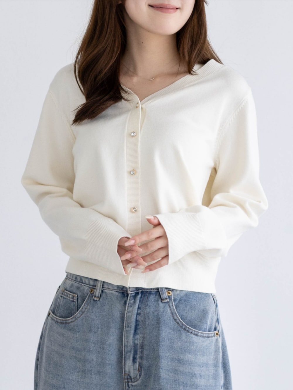 シルバー系のパンプス、ブルー系のデニムパンツ、ホワイト系のカーディガン/ボレロを着用したレディースの秋コーディネートの5枚目の写真