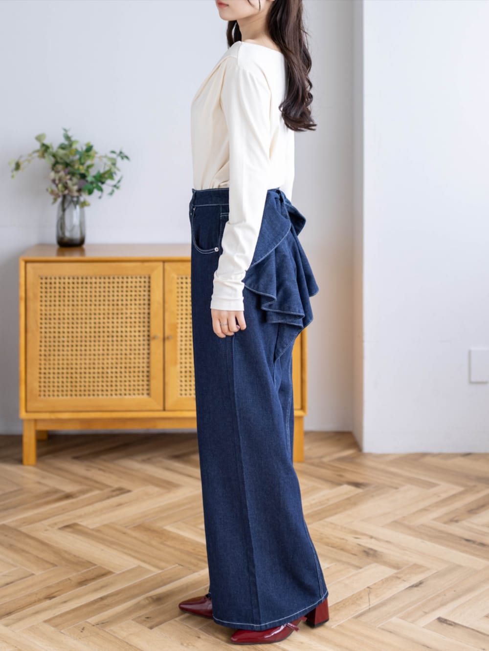 レッド系のパンプス、ブルー系のデニムパンツ、ホワイト系のTシャツ/カットソーを着用したレディースの秋コーディネートの3枚目の写真
