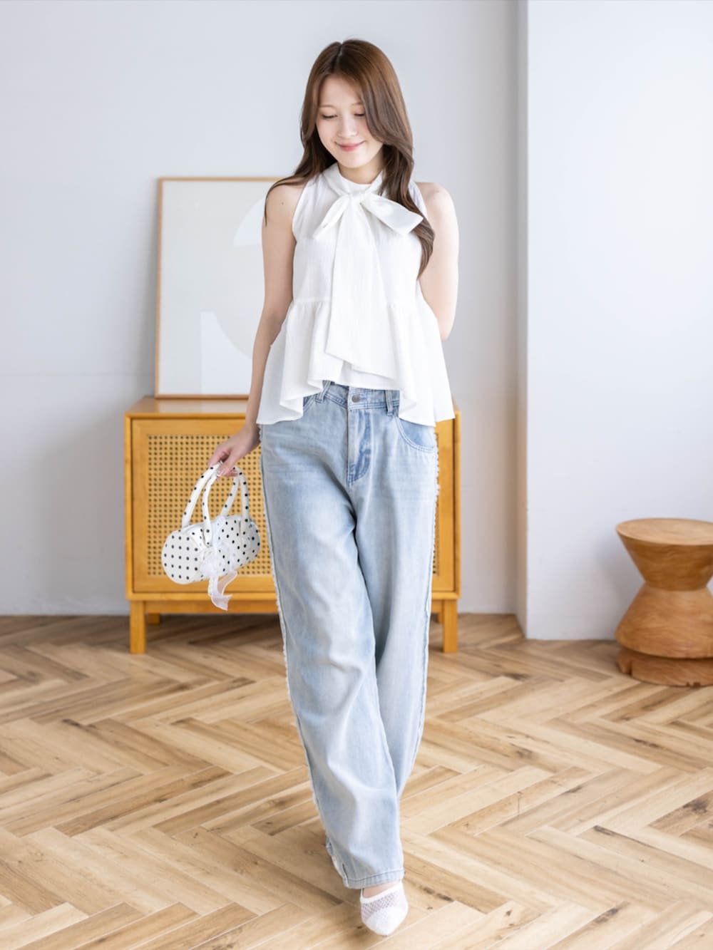 ブルー系のデニムパンツ、ホワイト系のパンプス、ホワイト系のシャツ/ブラウスを着用したレディースの夏コーディネートの2枚目の写真