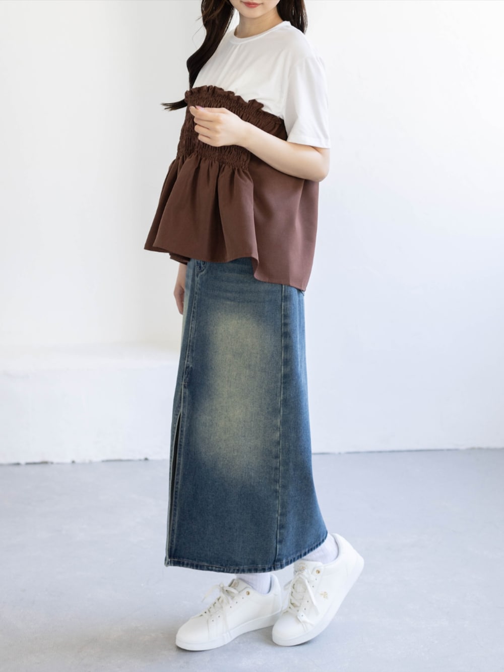 ブルー系のデニムスカート、ゴールド系のスニーカー、ブラウン系のTシャツ/カットソーを着用したレディースの夏コーディネートの5枚目の写真