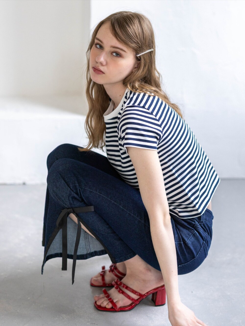 レッド系のサンダル、ブルー系のデニムパンツ、ホワイト系のTシャツ/カットソーを着用したレディースの夏コーディネートの7枚目の写真
