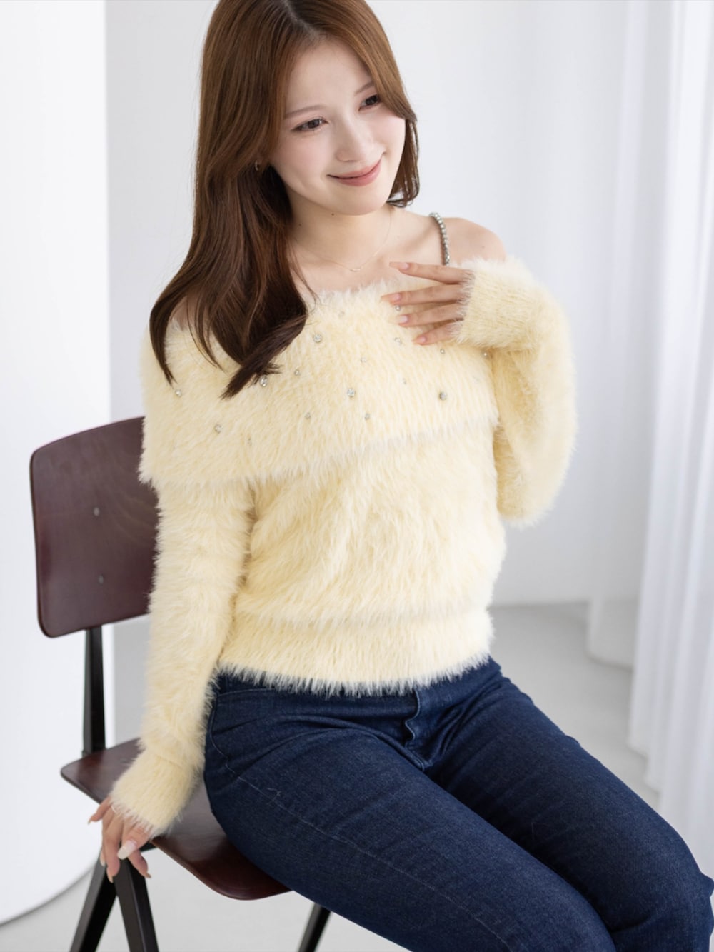 シルバー系のパンプス、ブルー系のデニムパンツ、イエロー系のニット/セーターを着用したレディースの秋コーディネートの2枚目の写真