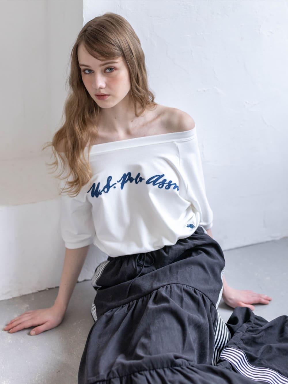 ブラック系のスニーカー、ブラック系のスカート、ホワイト系のTシャツ/カットソーを着用したレディースの夏コーディネートの6枚目の写真