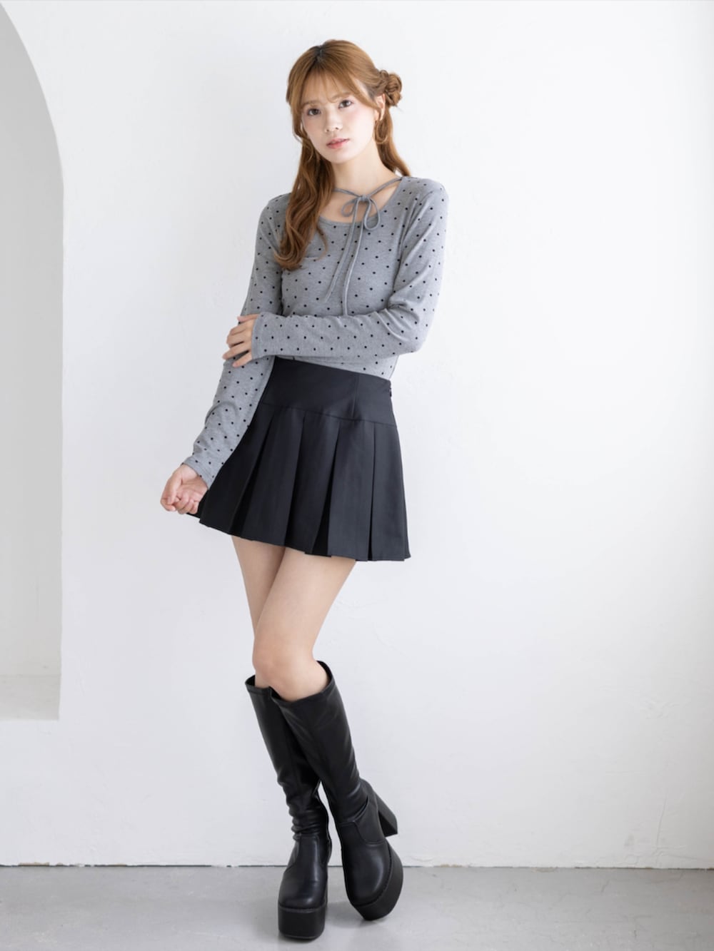 ブラック系のブーツ、ブラック系のスカート、グレー系のTシャツ/カットソーを着用したレディースの秋コーディネートの3枚目の写真