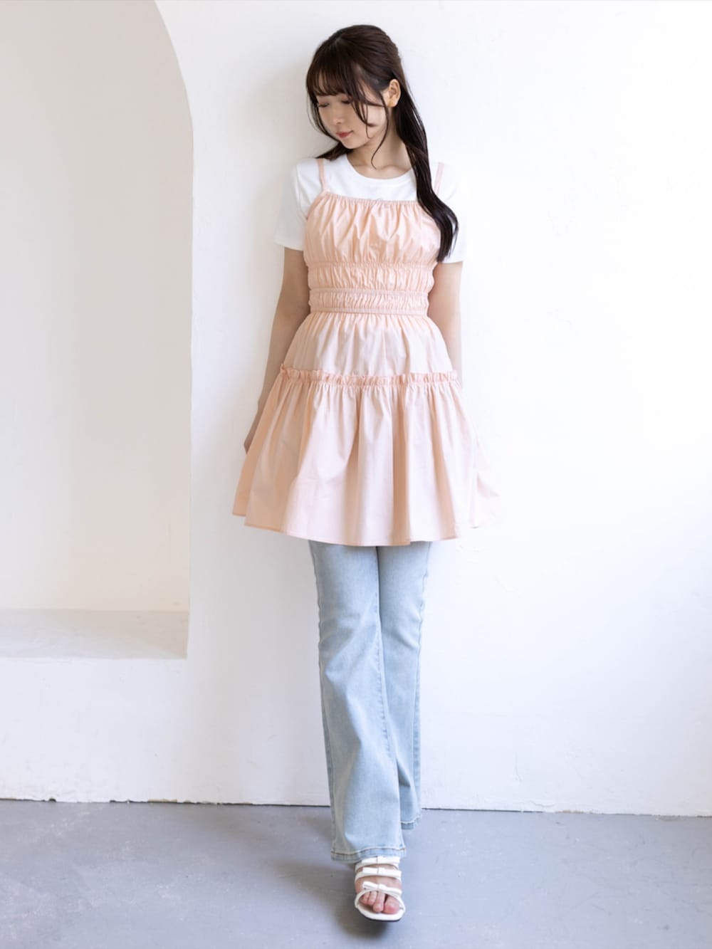ブルー系のデニムパンツ、ホワイト系のサンダル、ピンク系のワンピースを着用したレディースの夏コーディネートの3枚目の写真