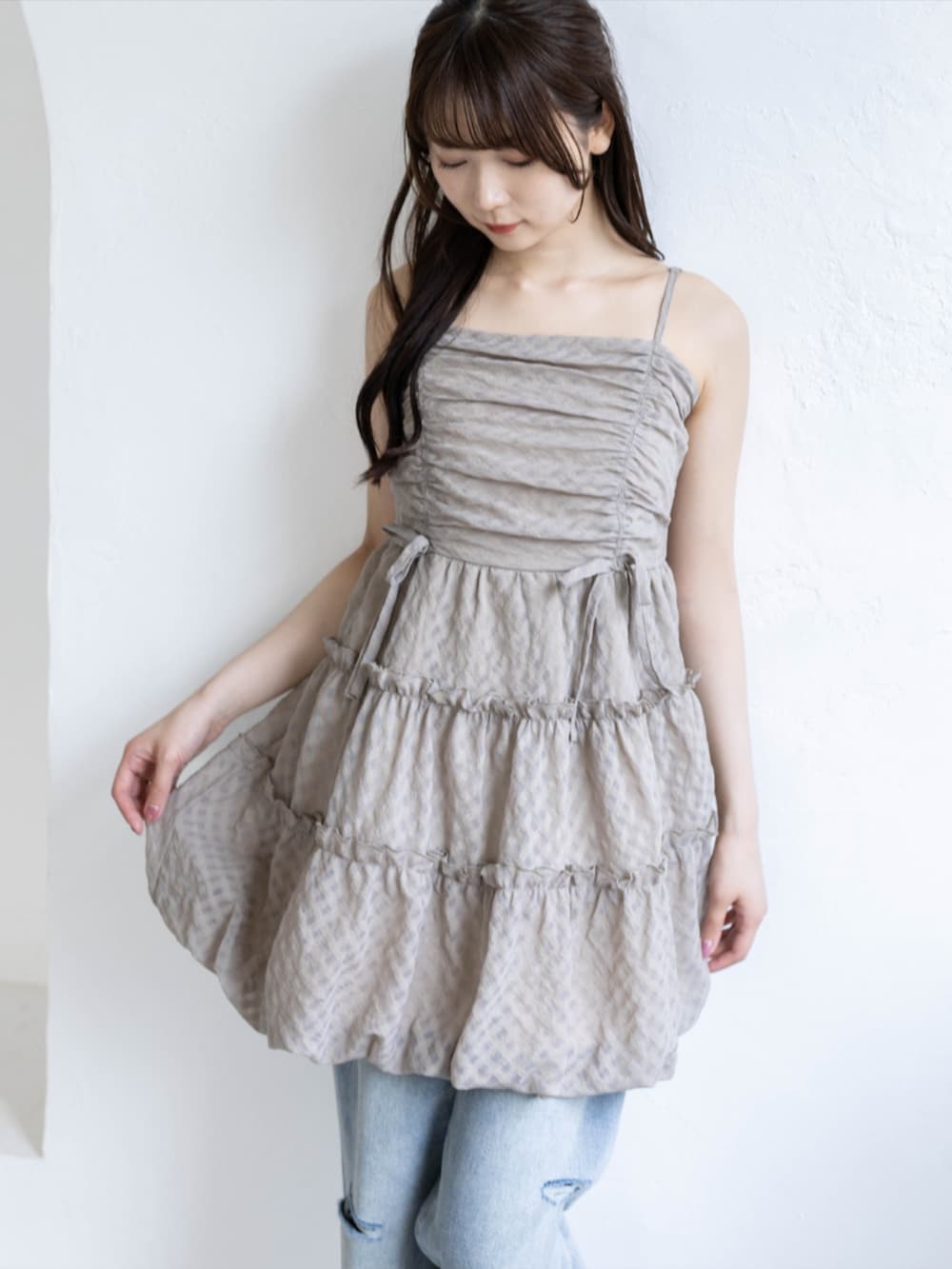 シルバー系のパンプス、ベージュ系のワンピース、ブルー系のデニムパンツを着用したレディースの夏コーディネートの7枚目の写真