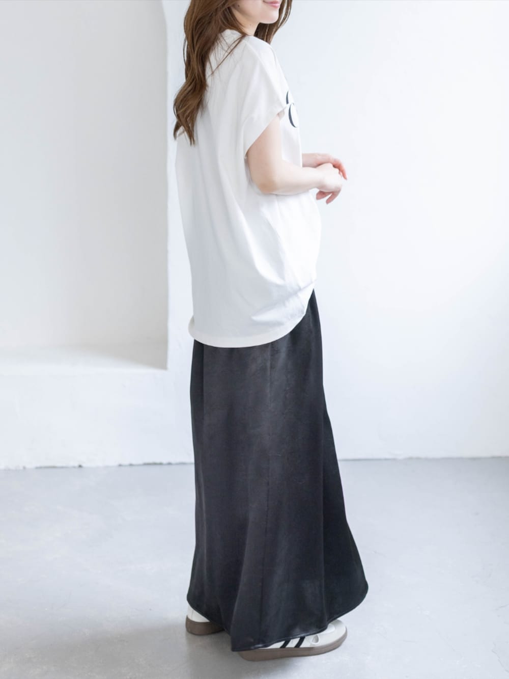 ホワイト系のスニーカー、ブラック系のスカート、ホワイト系のTシャツ/カットソーを着用したレディースの春コーディネートの4枚目の写真