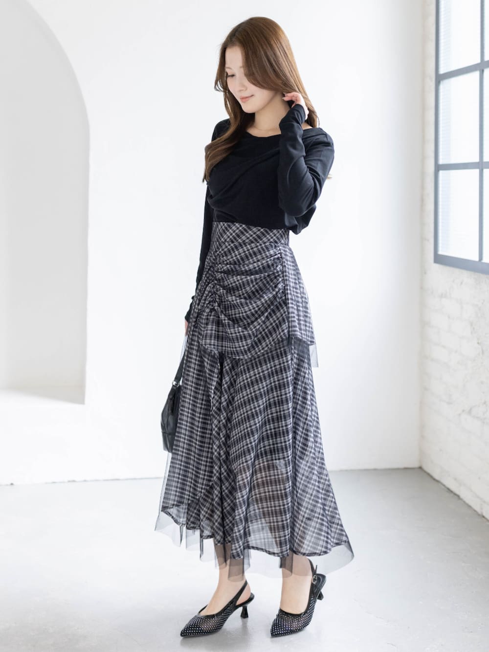 ブラック系のハンドバッグ、ブラック系のTシャツ/カットソー、ブラック系のスカートを着用したレディースの春コーディネートの2枚目の写真