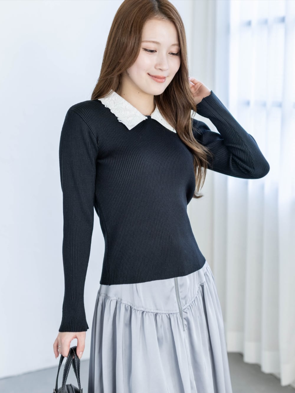 ブラック系のパンプス、グレー系のスカート、ブラック系のニット/セーターを着用したレディースの夏コーディネートの8枚目の写真