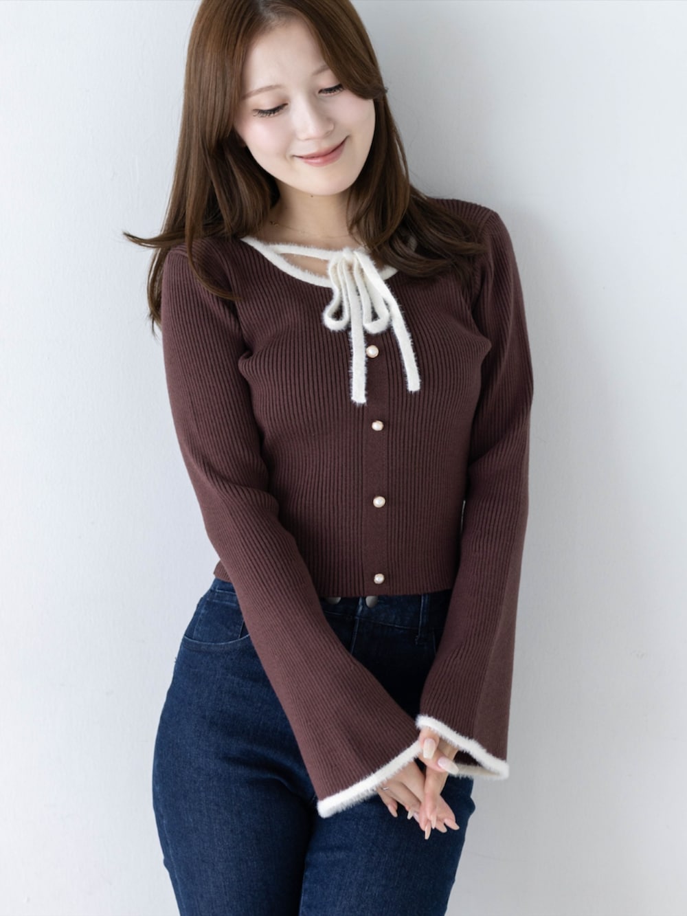 ブルー系のデニムパンツ、ブラック系のパンプス、ブラウン系のニット/セーターを着用したレディースの秋コーディネートの2枚目の写真