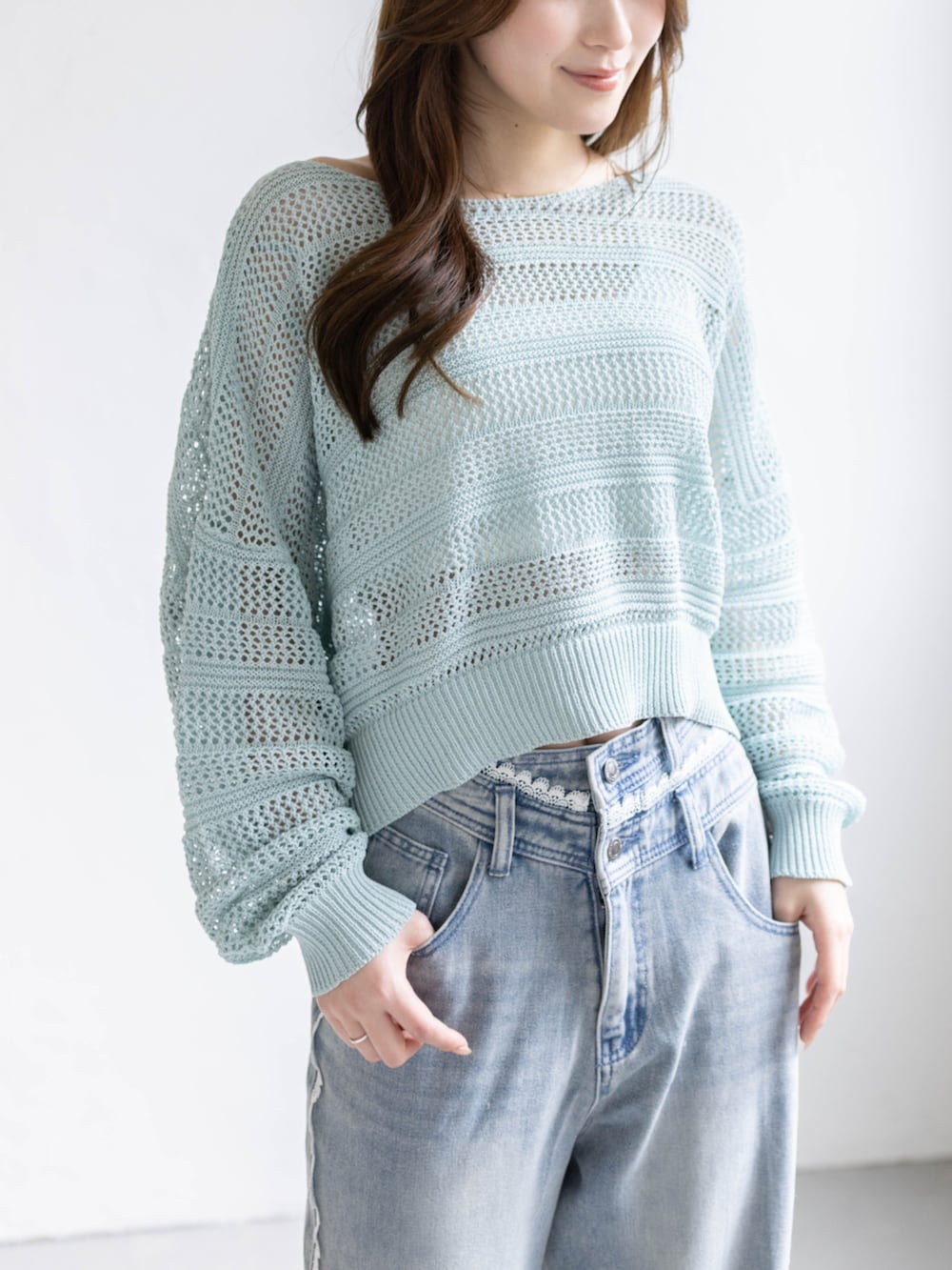 ホワイト系のパンプス、ブルー系のデニムパンツ、グリーン系のニット/セーターを着用したレディースの春コーディネートの3枚目の写真