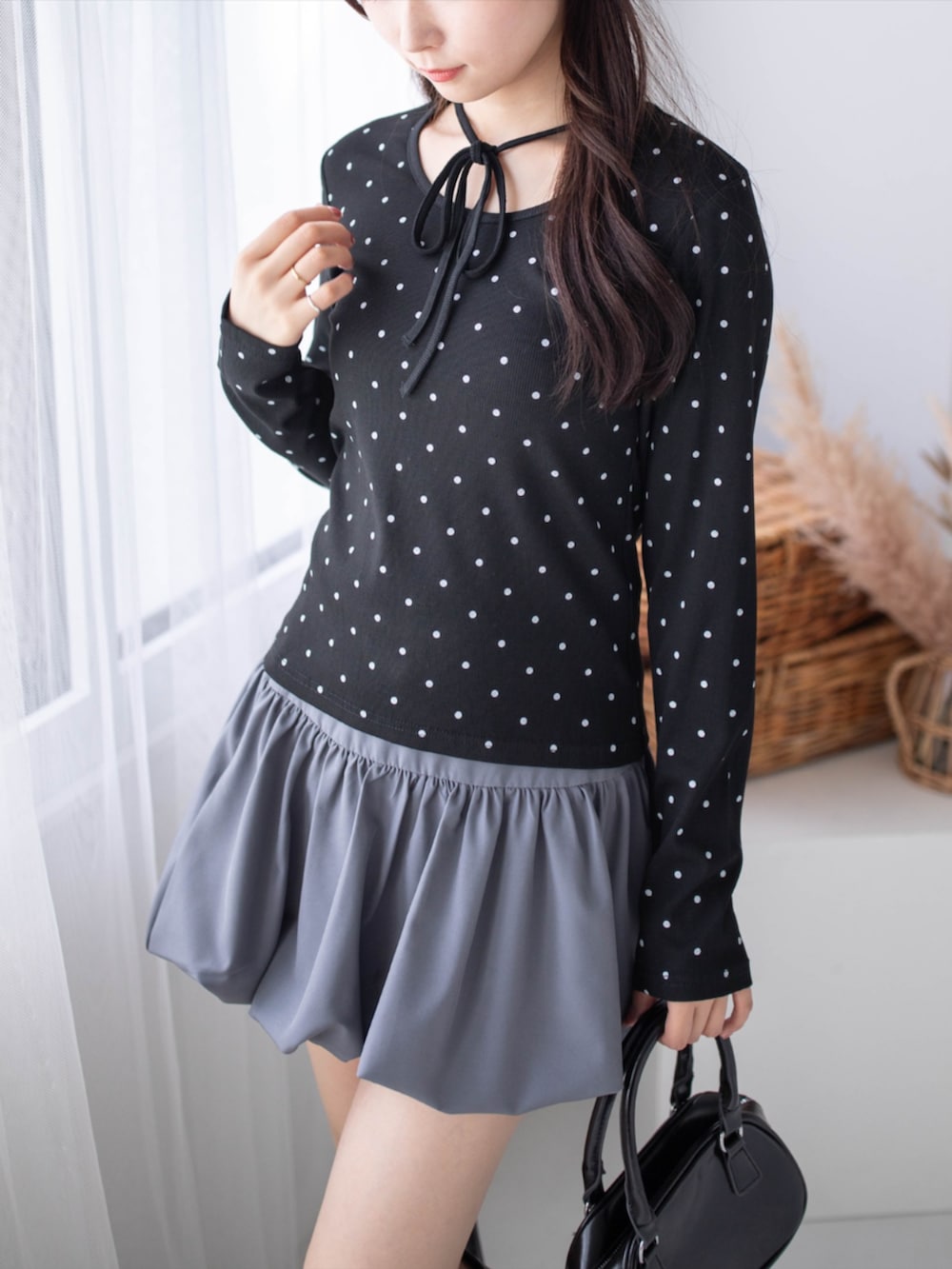グレー系のスカート、ブラック系のブーツ、ブラック系のTシャツ/カットソーを着用したレディースの秋コーディネートの5枚目の写真