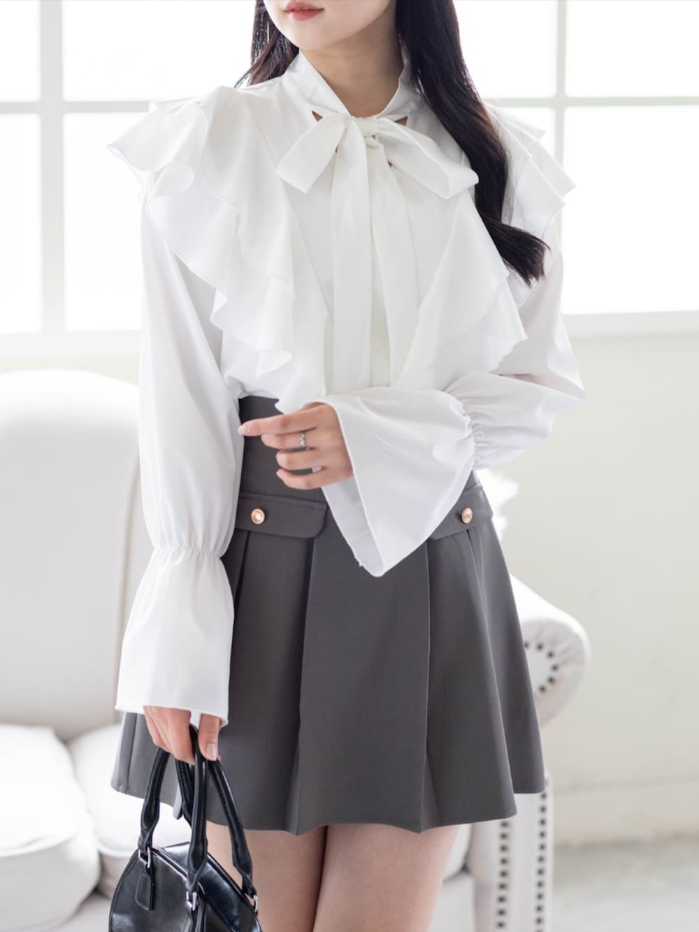 ブラック系のパンプス、グレー系のスカート、ホワイト系のシャツ/ブラウスを着用したレディースの夏コーディネートの3枚目の写真