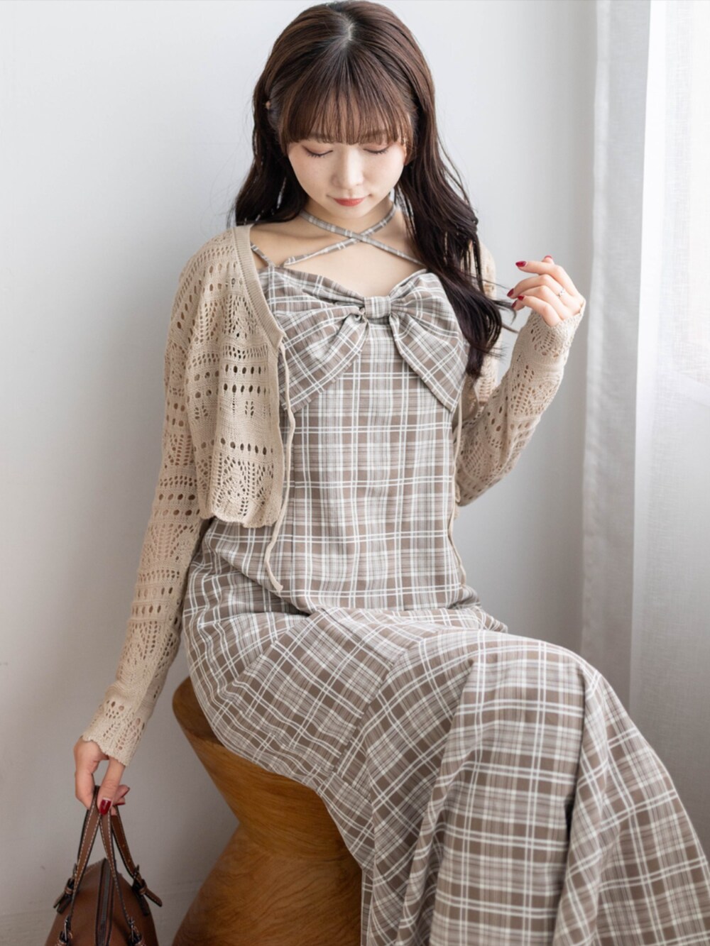ベージュ系のボストンバッグ、ホワイト系のパンプス、ブラウン系のニット/セーターを着用したレディースの春コーディネートの4枚目の写真