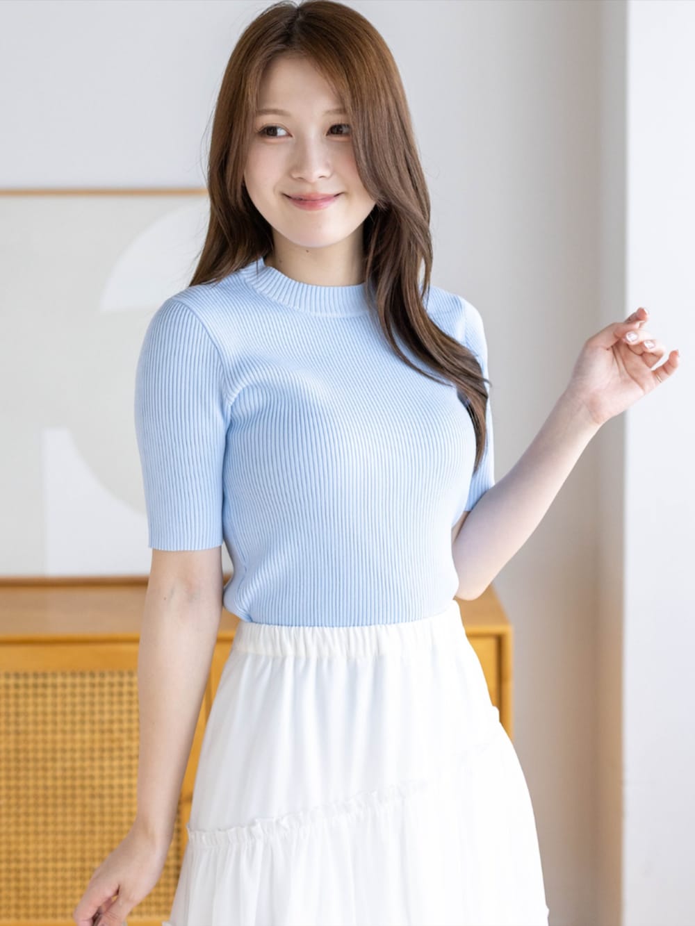 ブルー系のニット/セーター、ホワイト系のハンドバッグ、ホワイト系のパンプスを着用したレディースの夏コーディネートの4枚目の写真