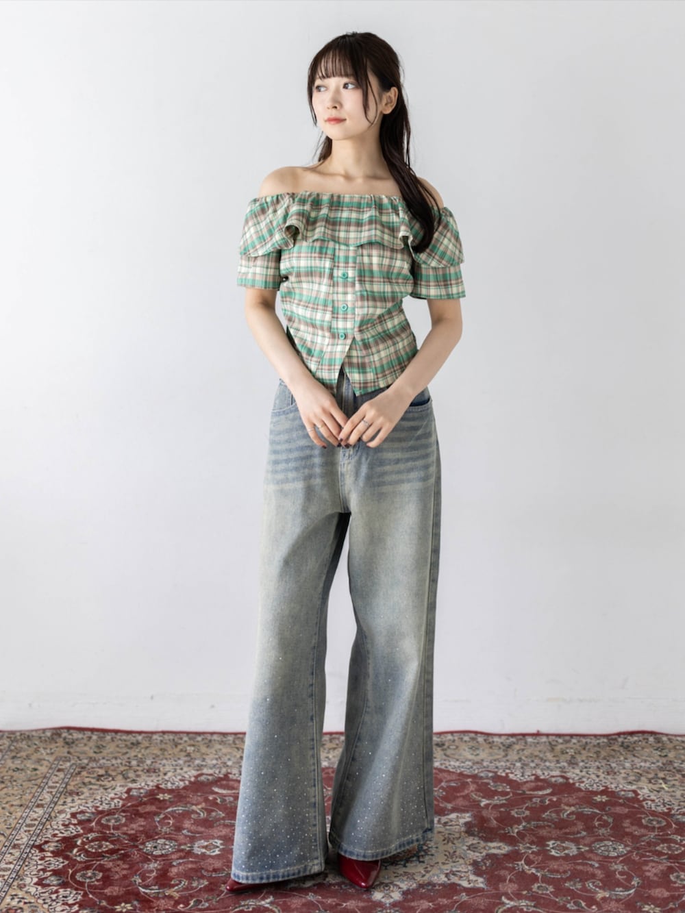 レッド系のパンプス、ブルー系のデニムパンツ、グリーン系のシャツ/ブラウスを着用したレディースの夏コーディネートの2枚目の写真