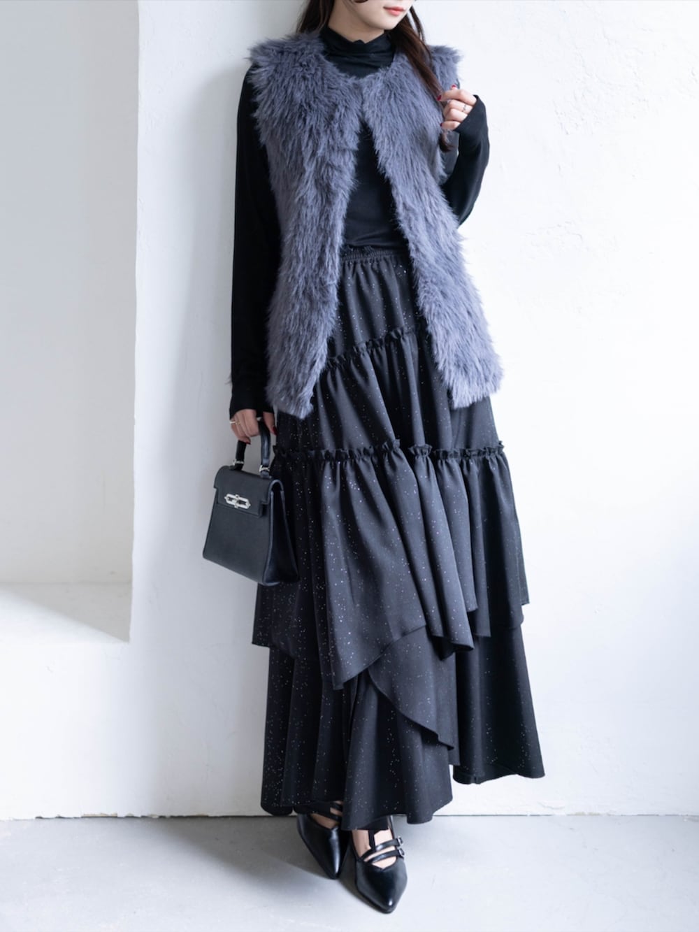 ブラック系のハンドバッグ、ブラック系のTシャツ/カットソー、グレー系のスカートを着用したレディースの秋コーディネートの2枚目の写真