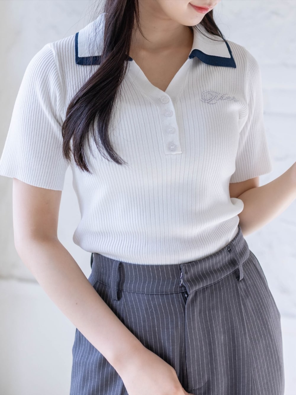 ホワイト系のスニーカー、ブラック系のハンドバッグ、グレー系のスラックスを着用したレディースの春コーディネートの4枚目の写真