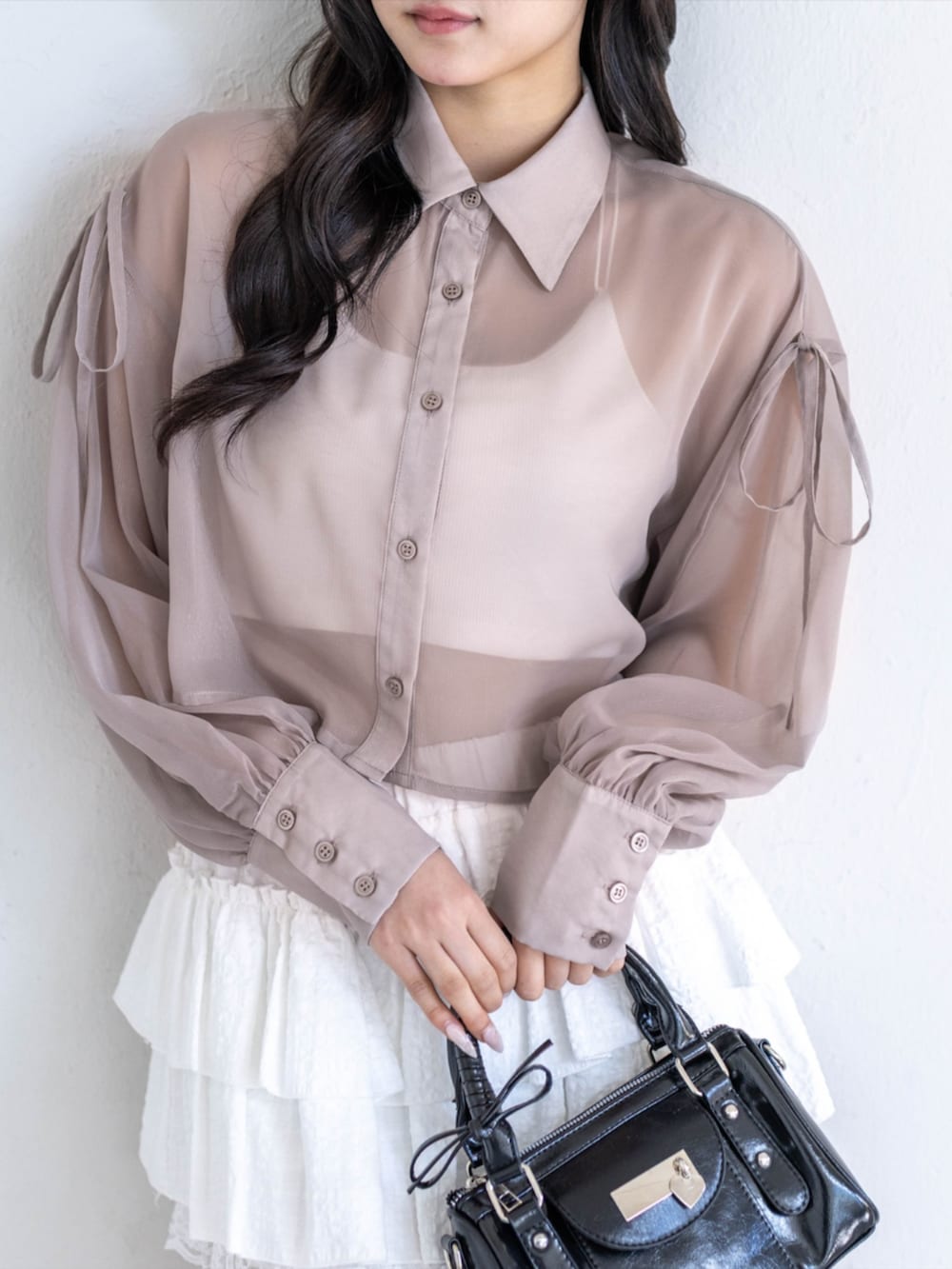 ブラック系のパンプス、ホワイト系のスカート、ブラック系のハンドバッグを着用したレディースの春コーディネートの3枚目の写真