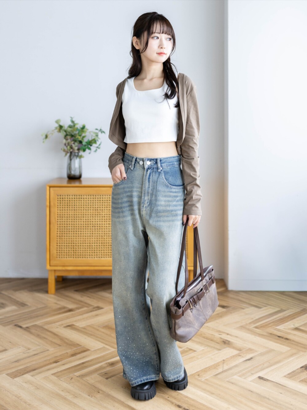 ブラウン系のショルダーバッグ、ブルー系のデニムパンツ、ブラウン系のカーディガン/ボレロを着用したレディースの夏コーディネートの4枚目の写真