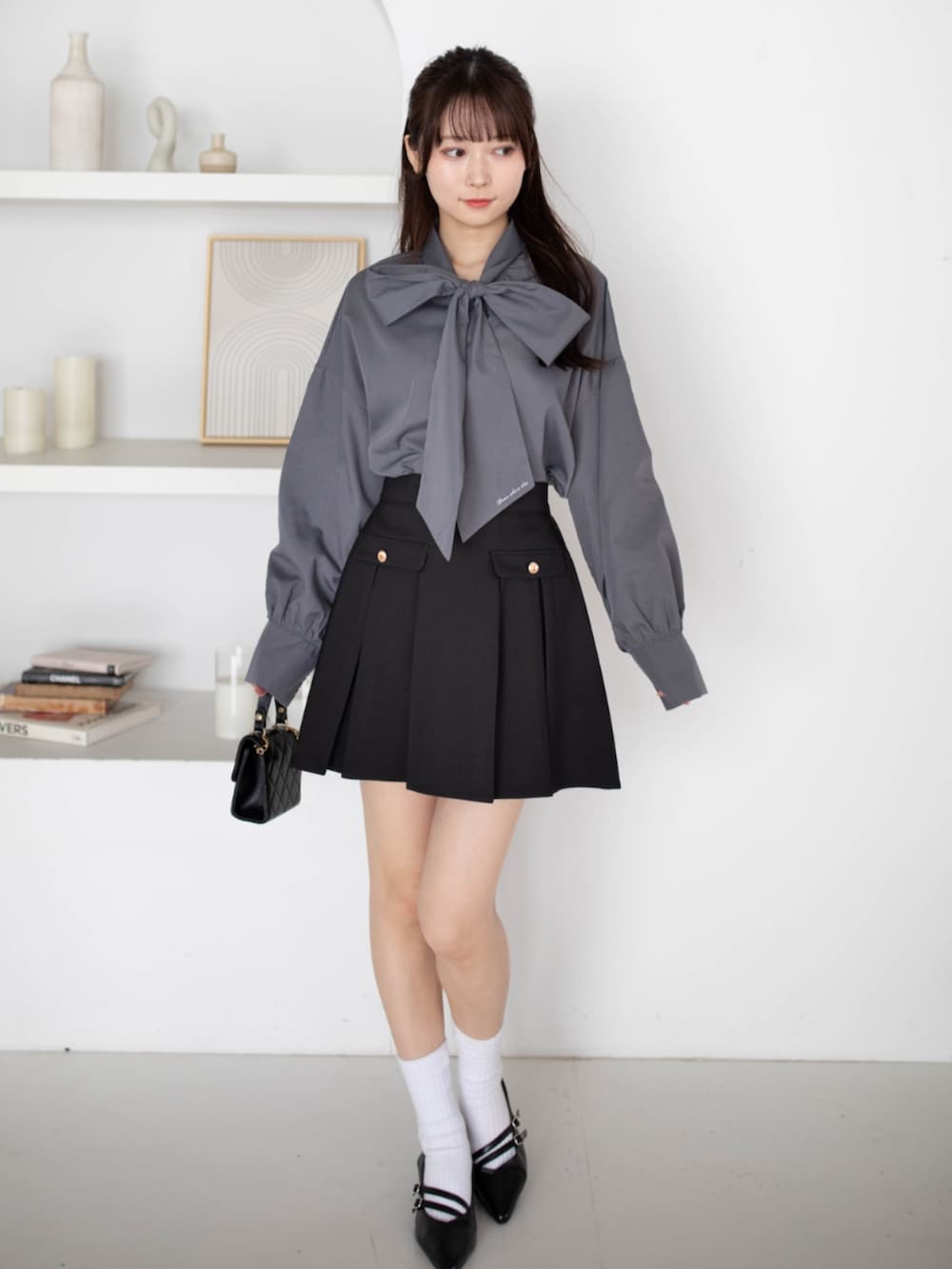 ブラック系のパンプス、グレー系のシャツ/ブラウス、ブラック系のスカートを着用したレディースの夏コーディネートの3枚目の写真
