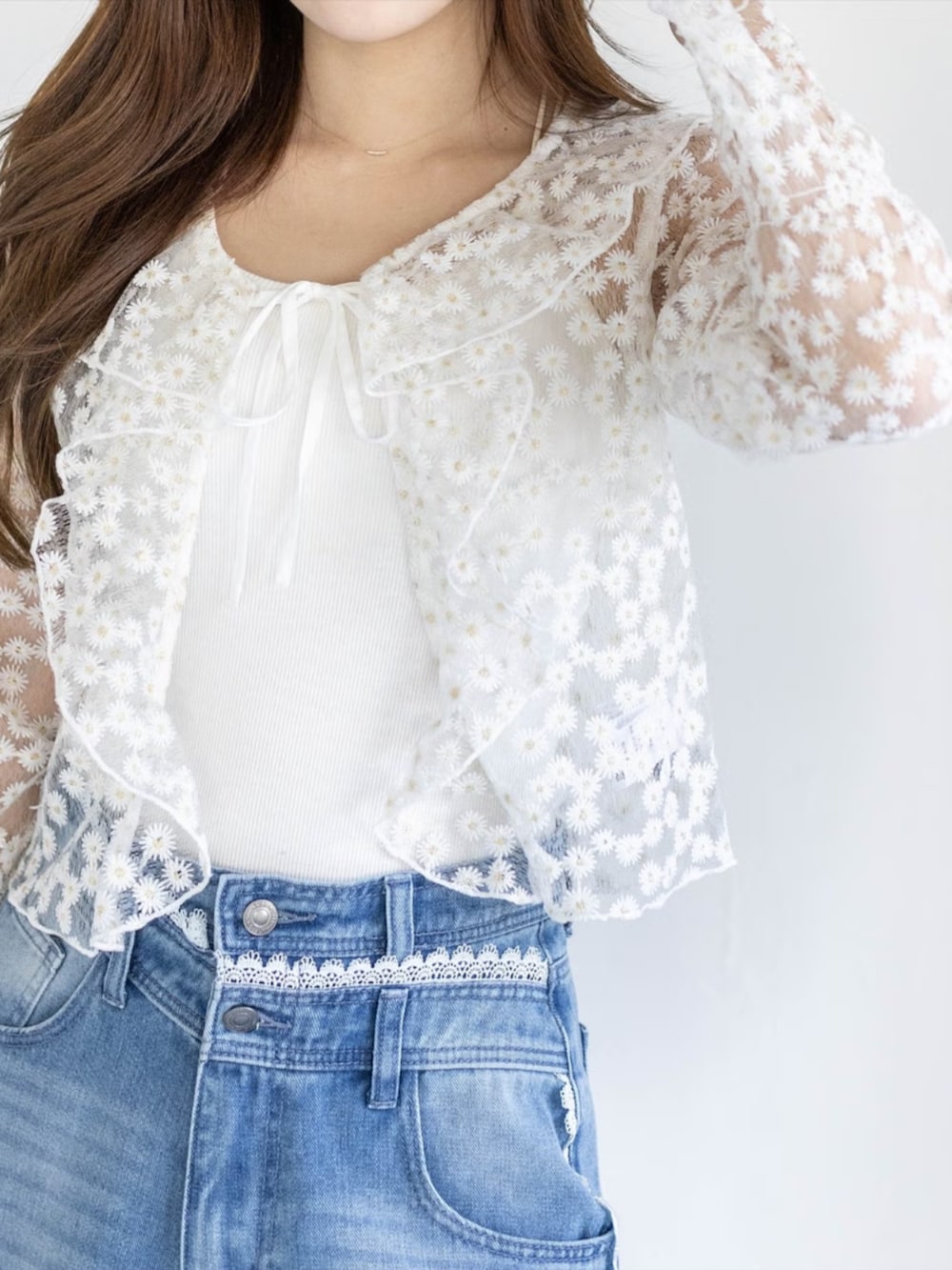 ブルー系のデニムパンツ、ホワイト系のパンプス、ホワイト系のカーディガン/ボレロを着用したレディースの春コーディネートの4枚目の写真