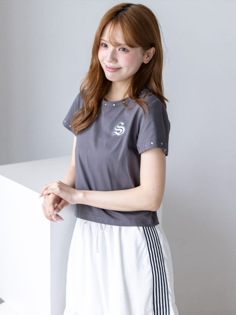 ブラック系のブーツ、ホワイト系のスカート、グレー系のTシャツ/カットソーを着用したレディースの夏コーディネートの8枚目の写真