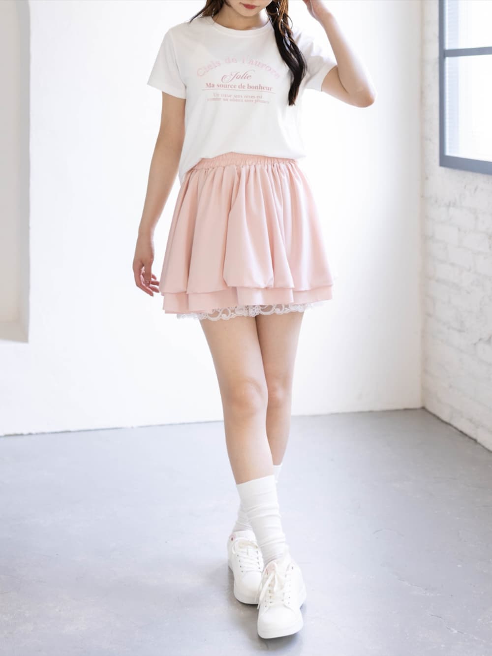 ピンク系のスニーカー、ピンク系のスカート、ホワイト系のTシャツ/カットソーを着用したレディースの夏コーディネートの2枚目の写真
