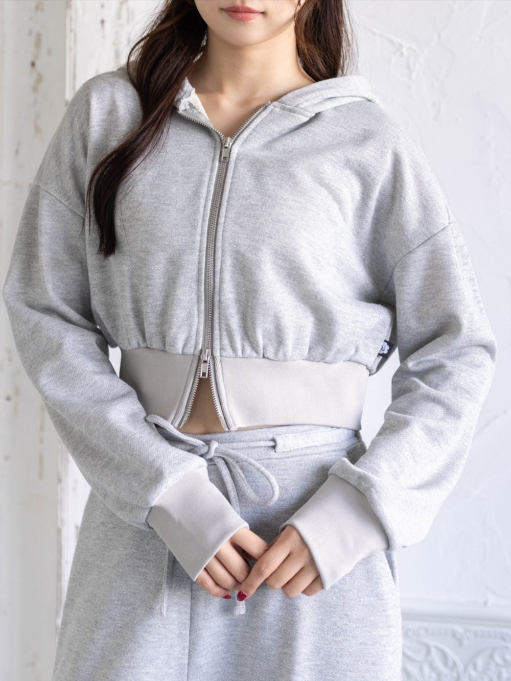 グレー系のスウェットパンツ、ゴールド系のスニーカー、グレー系のパーカーを着用したレディースの夏コーディネートの5枚目の写真