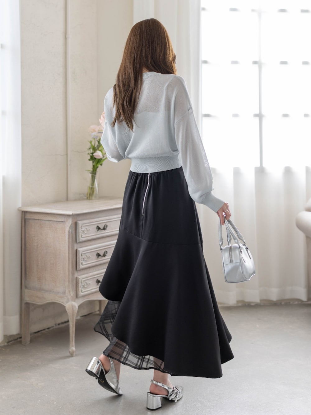 シルバー系のパンプス、ブラック系のスカート、グレー系のカーディガン/ボレロを着用したレディースの春コーディネートの2枚目の写真