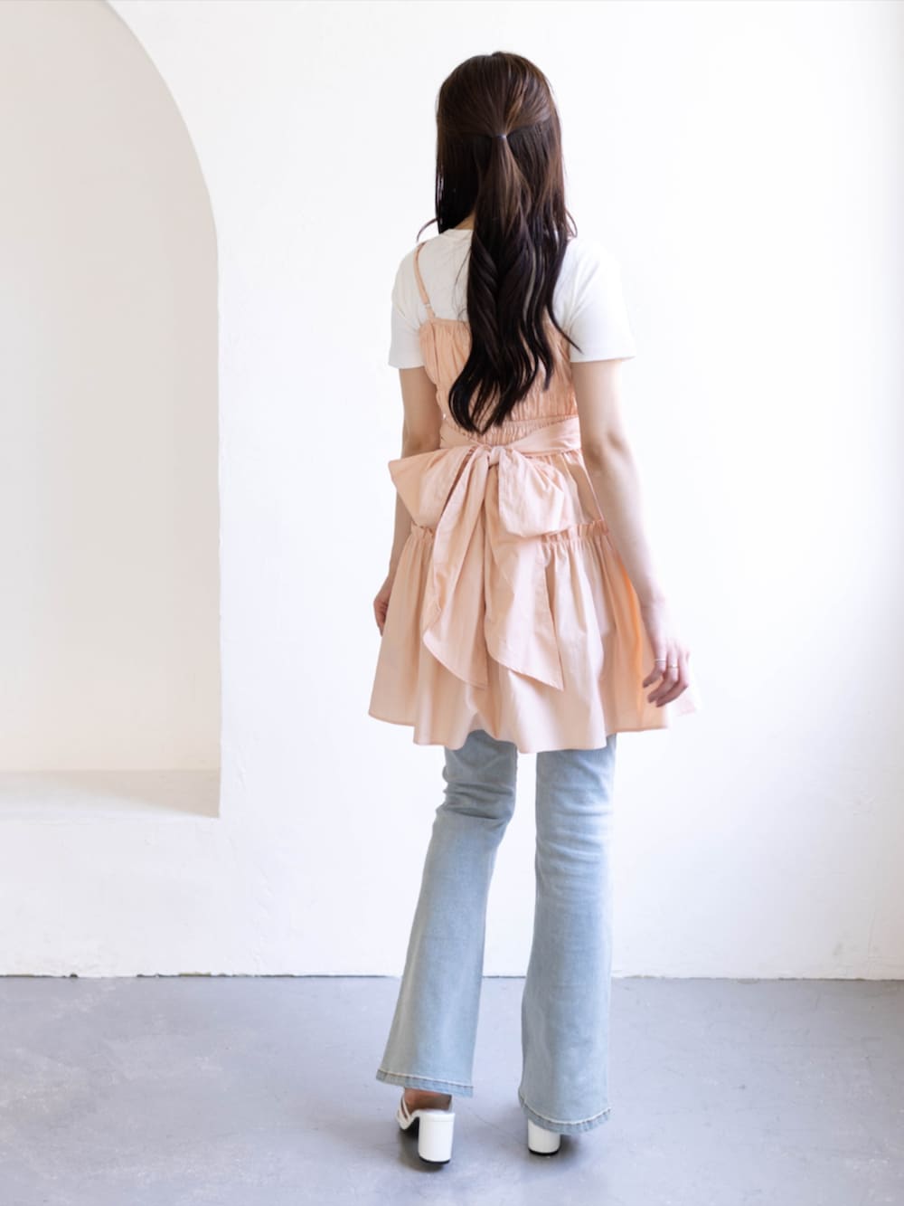 ブルー系のデニムパンツ、ホワイト系のサンダル、ピンク系のワンピースを着用したレディースの夏コーディネートの2枚目の写真