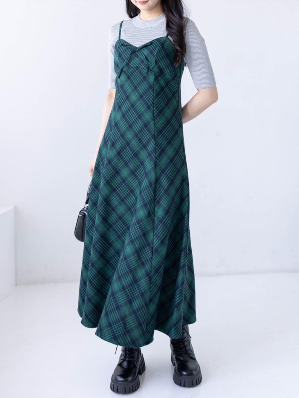 グレー系のニット/セーター、ブラック系のブーツ、グリーン系のワンピースを着用したレディースの春コーディネートの3枚目の写真