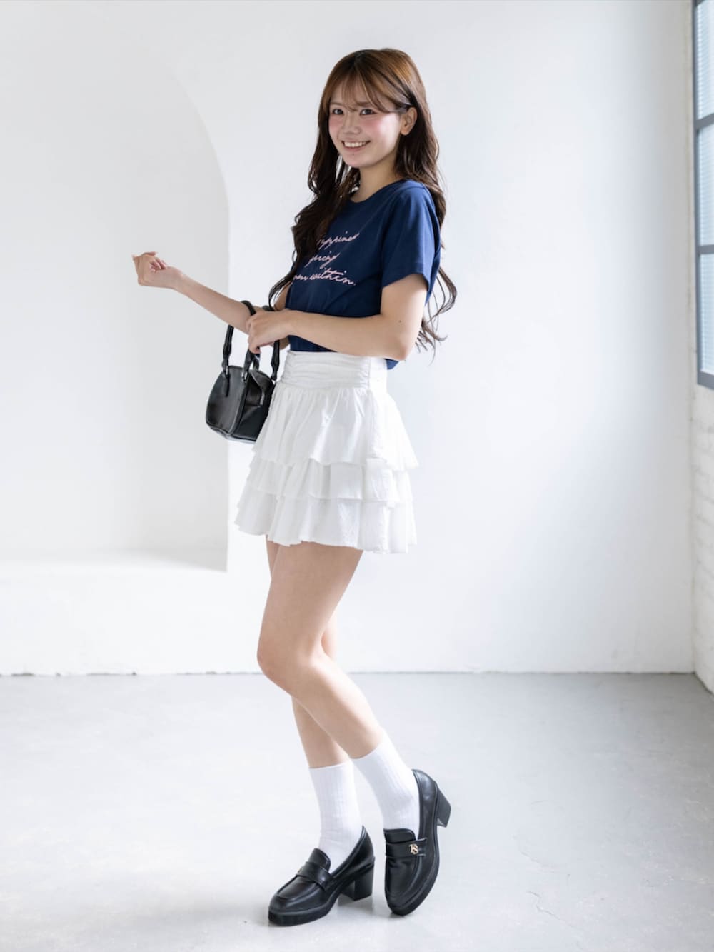 ブラック系のローファー、ホワイト系のスカート、ブルー系のTシャツ/カットソーを着用したレディースの春コーディネートの3枚目の写真