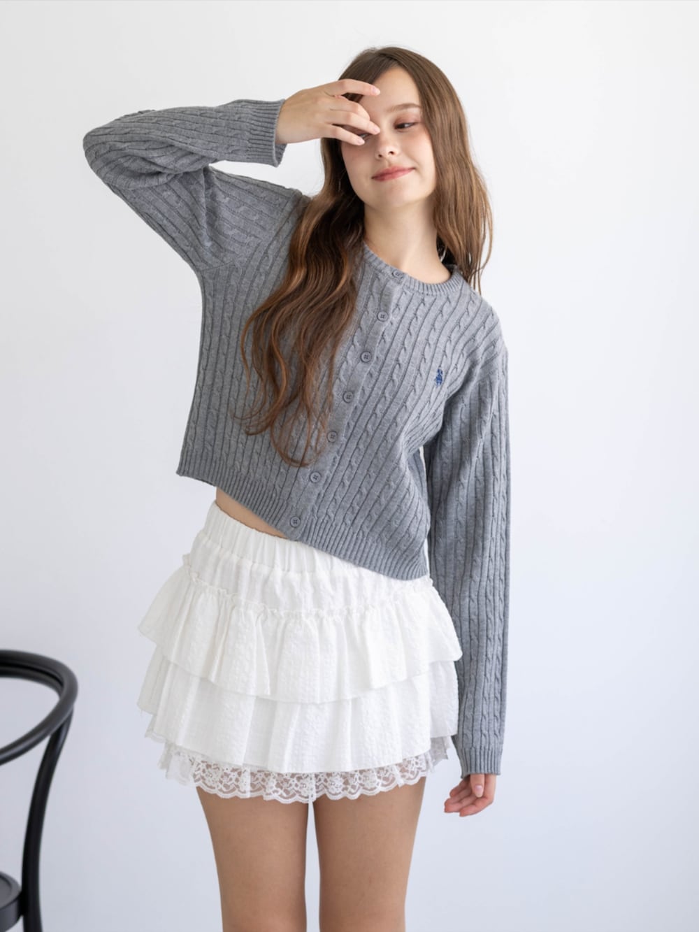 レッド系のパンプス、グレー系のカーディガン/ボレロ、ホワイト系のスカートを着用したレディースの秋コーディネートの4枚目の写真