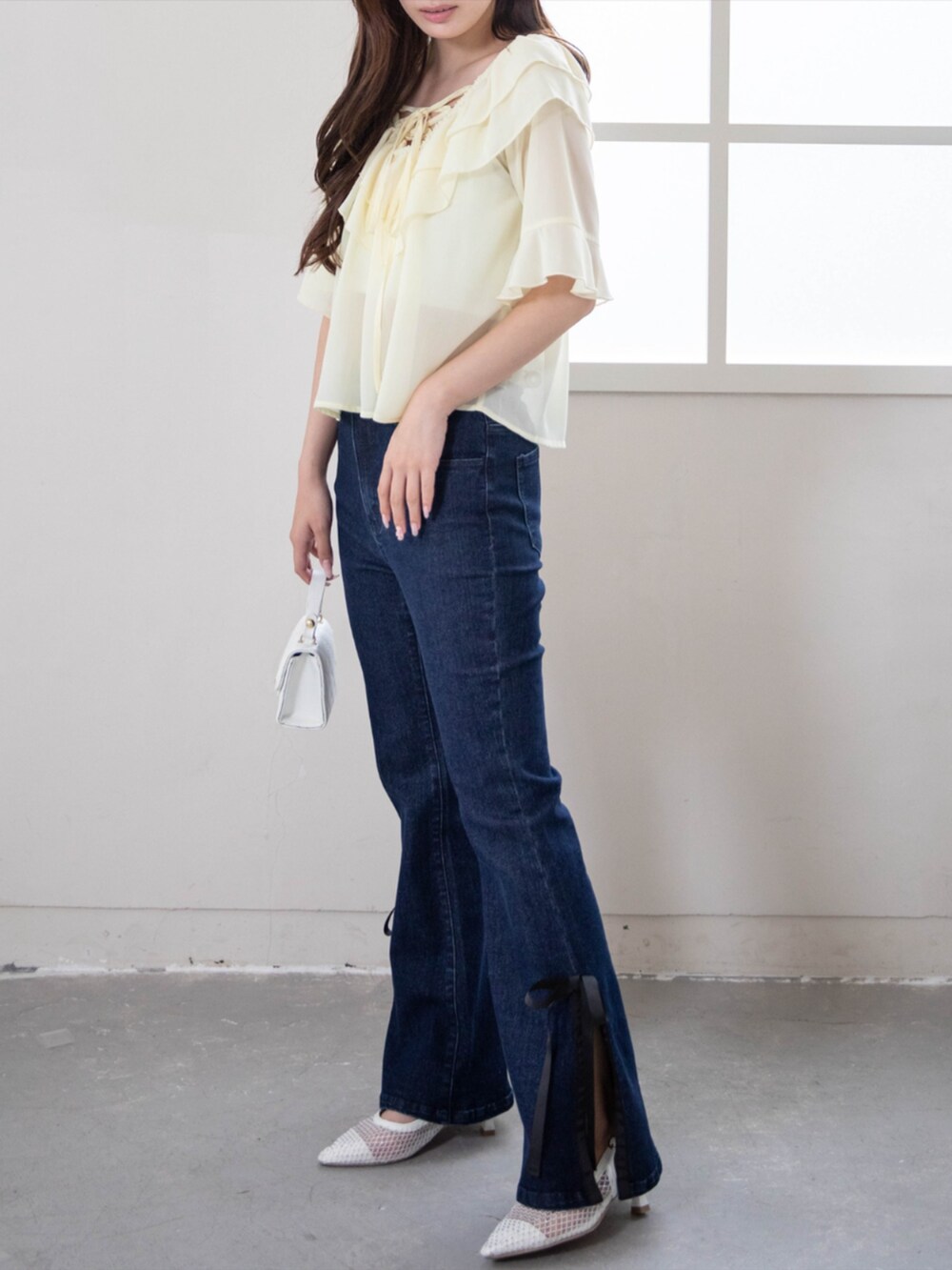 ホワイト系のパンプス、ブルー系のデニムパンツ、イエロー系のシャツ/ブラウスを着用したレディースの夏コーディネートの2枚目の写真